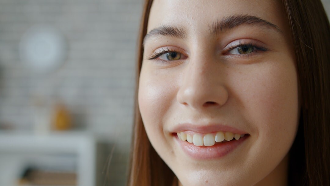 Mujer joven sonriendo mirando a cámara